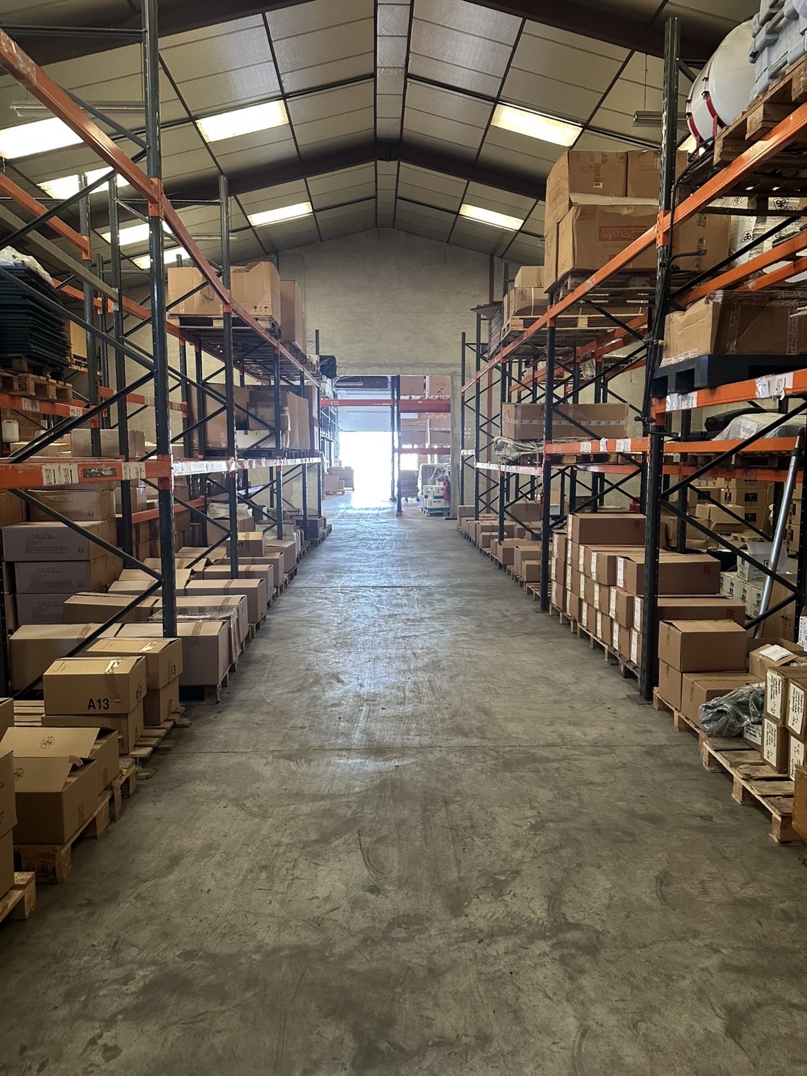 Intérieur de l'entrepôt Urgence Absolue — allée de racks